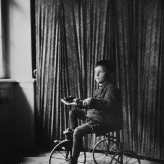 fotografia Jozefa Sedláka z cyklu „Latency”; przedstawia chłopca siedzących na rowerku fotografia jest czarno-biała