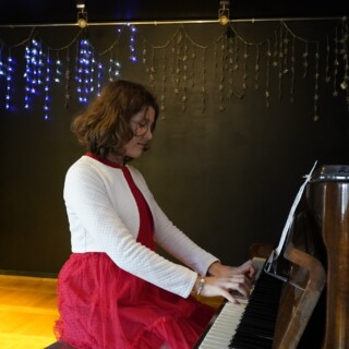 uczestniczka zajęć artystycznych grająca na pianinie podczas koncertu bożonarodzeniowego w domu kultury śródmieście w białymstoku